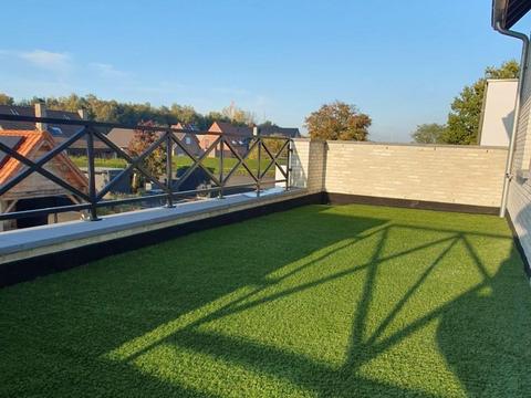 Dakterras met kunstgras en zicht over de omliggende woningen