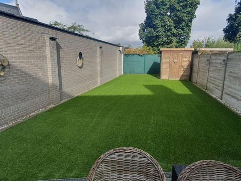 Dezelfde tuin na de plaatsing van het kunstgras
