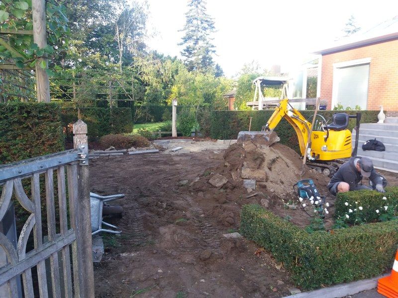 Graafmachine bij het uitgraven van een tuin voor kunstgras