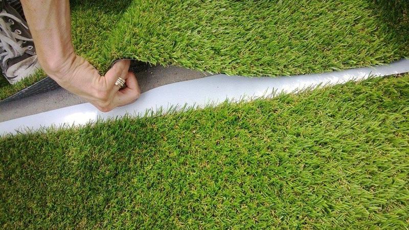 Naadband wordt onder twee stroken kunstgras gelegd