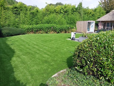 Ruime achtertuin met kunstgras en tuinkantoor in Herenthout