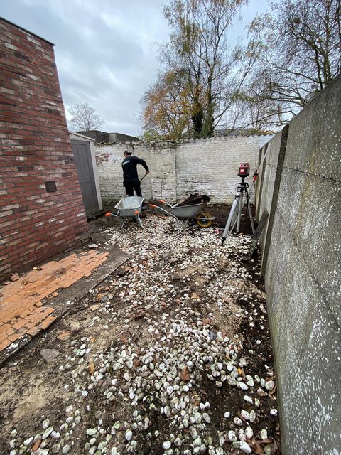Ommuurde achtertuin in Beveren-Waas tijdens het grondwerk: de oude grindlaag gaat eruit