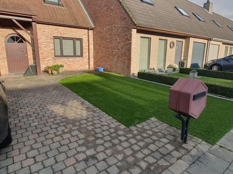 Voortuin met kunstgras tussen de klinkers, gezien vanaf de straat