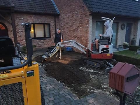 Twee minigraafmachines en een ploeg tijdens het grondwerk voor een voortuin