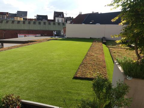 Grande toiture-terrasse avec gazon artificiel et zone plantée au-dessus d&rsquo;un immeuble, à Bruxelles