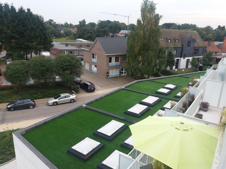 Dakterras met parasols en kunstgras