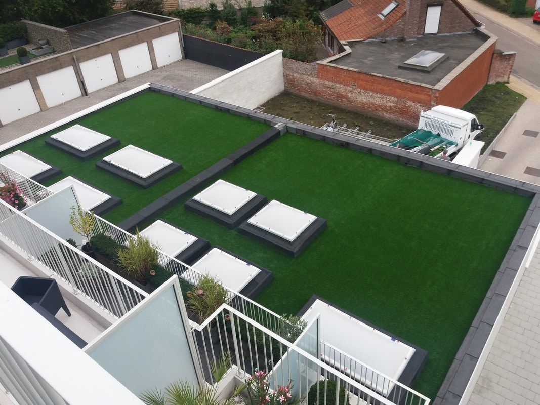 Dakterras met kunstgras en betonnen looptegels