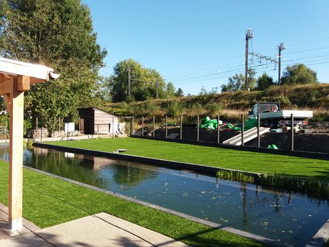 Kunstgras in ForGrass Impres rond een zwemvijver met houten overkapping in Deinze