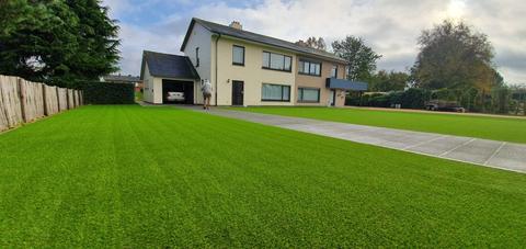 Grote voortuin met kunstgras naast de oprit van een villa in Eeklo