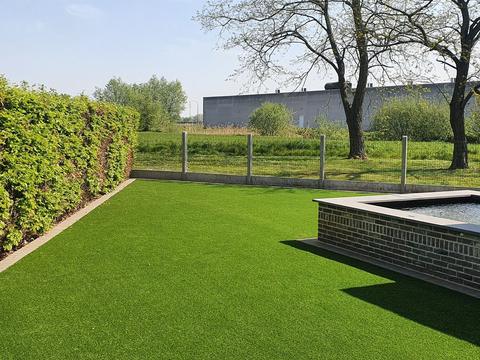 Gazon artificiel jusque contre la haie et la clôture, à Izegem