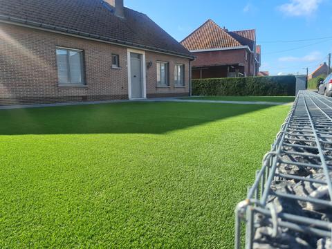 Jardin de façade avec gazon artificiel et un gabion en bordure, à Harelbeke