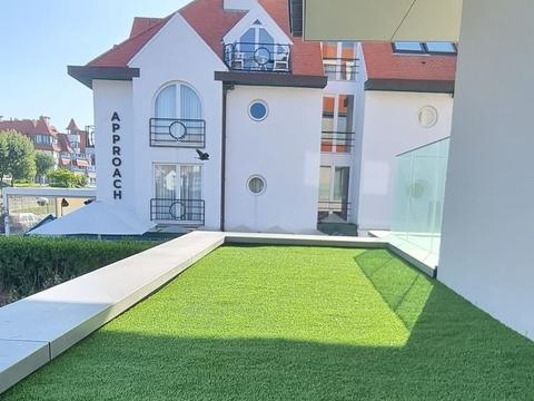 Dakterras met kunstgras bij een appartementsgebouw aan de kust