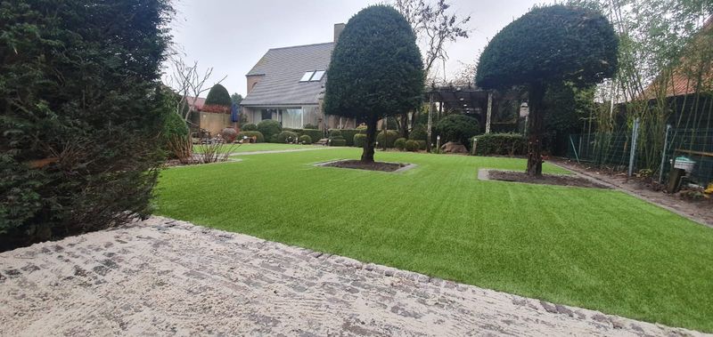 Tuin met kunstgras rond een vijver op polderklei bij Knokke, vlak bij de Nederlandse grens