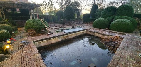 Oude siervijver in een tuin met snoeivormen in Knokke-Heist, vóór het opvullen
