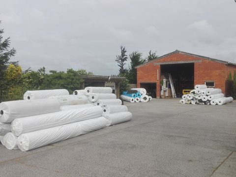 Een nieuwe levering rollen kunstgras op het erf voor de loods in Meigem