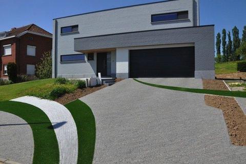 Allée avec bandes de gazon artificiel entre le revêtement, à Deurle, vue de la rue