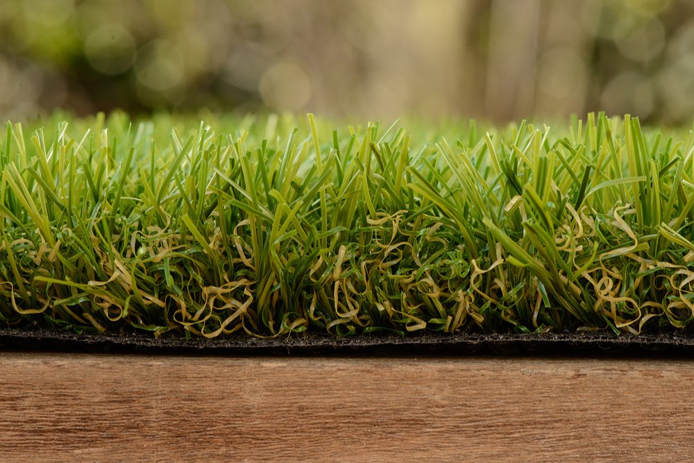 Zijaanzicht van ForGrass Excellence: kunstgras van 40 millimeter met zichtbare vezels en bruine krul