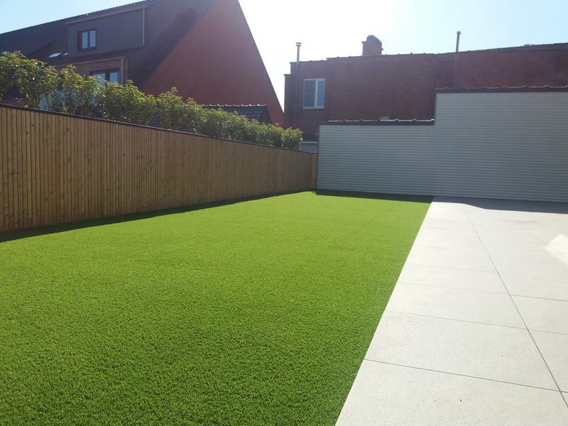 Dakterras in Torhout met kunstgras naast lichte tegels en een houten wand