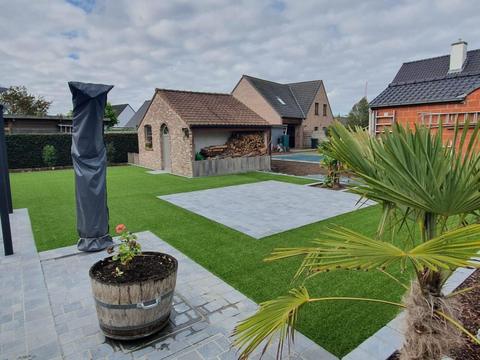 Tuin met kunstgras, klinkerterras en palmbomen