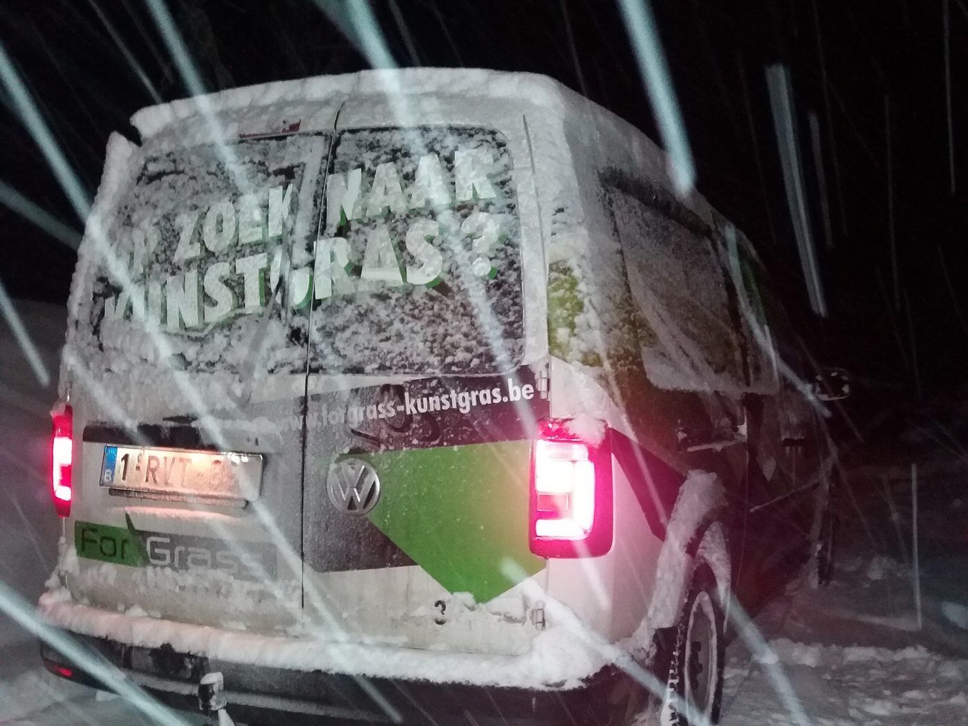 Bestelwagen van ForGrass in een sneeuwbui bij nacht