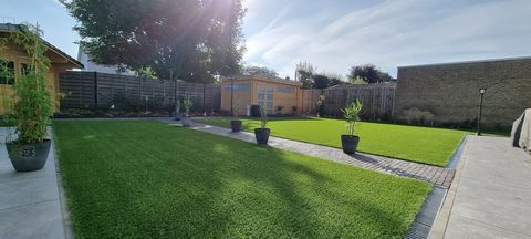 Grote tuin in Zulte met kunstgras, klinkerpad en tuinhuis